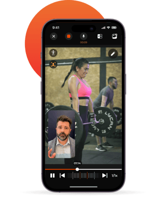 iphone showing woman wearing pink sports bra weightlifting in gym using coachcam feature in coachnow app